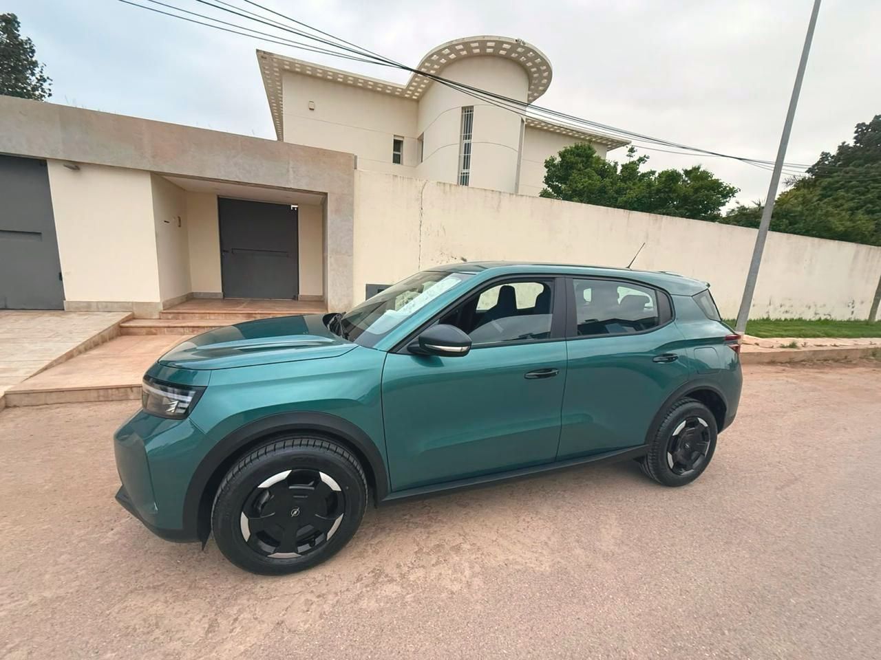 Citroën C3 verte devant une villa blanche
